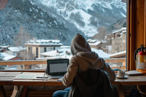 Voyageur réservant une auberge de jeunesse pas chère en Andorre, comparant les prix et les avis sur son ordinateur portable