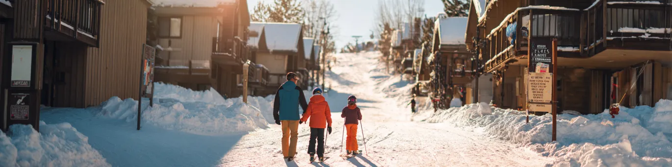 Famille en vacances de ski profitant d’un séjour pas cher dans une station conviviale, hébergée tout près des pistes enneigées